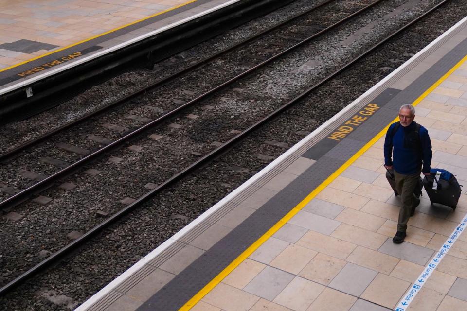 A man with suitcases at an empty Paddington station (PA)