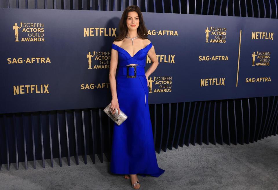 Anne Hathaway wears a blue belted dress at the SAG Awards.