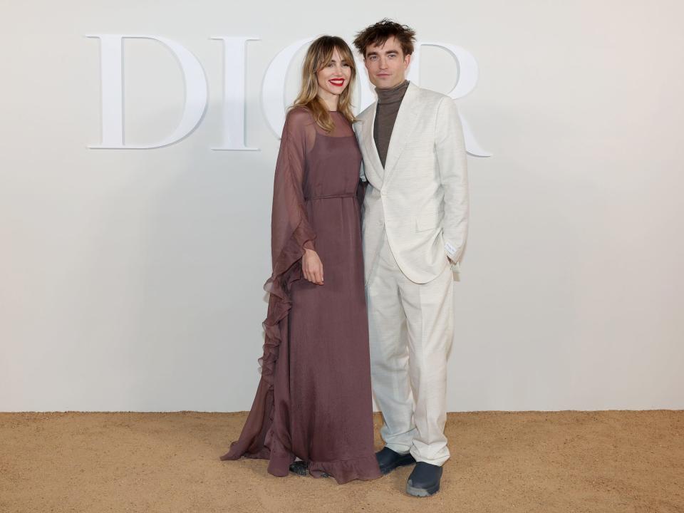 Suki Waterhouse and Robert Pattinson on a red carpet.