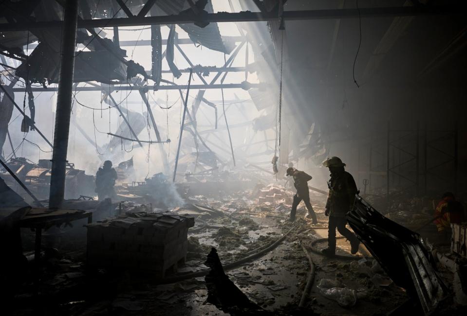 Ukrainian rescuers work at the site of a shelling on the printing business in Kharkiv (EPA)