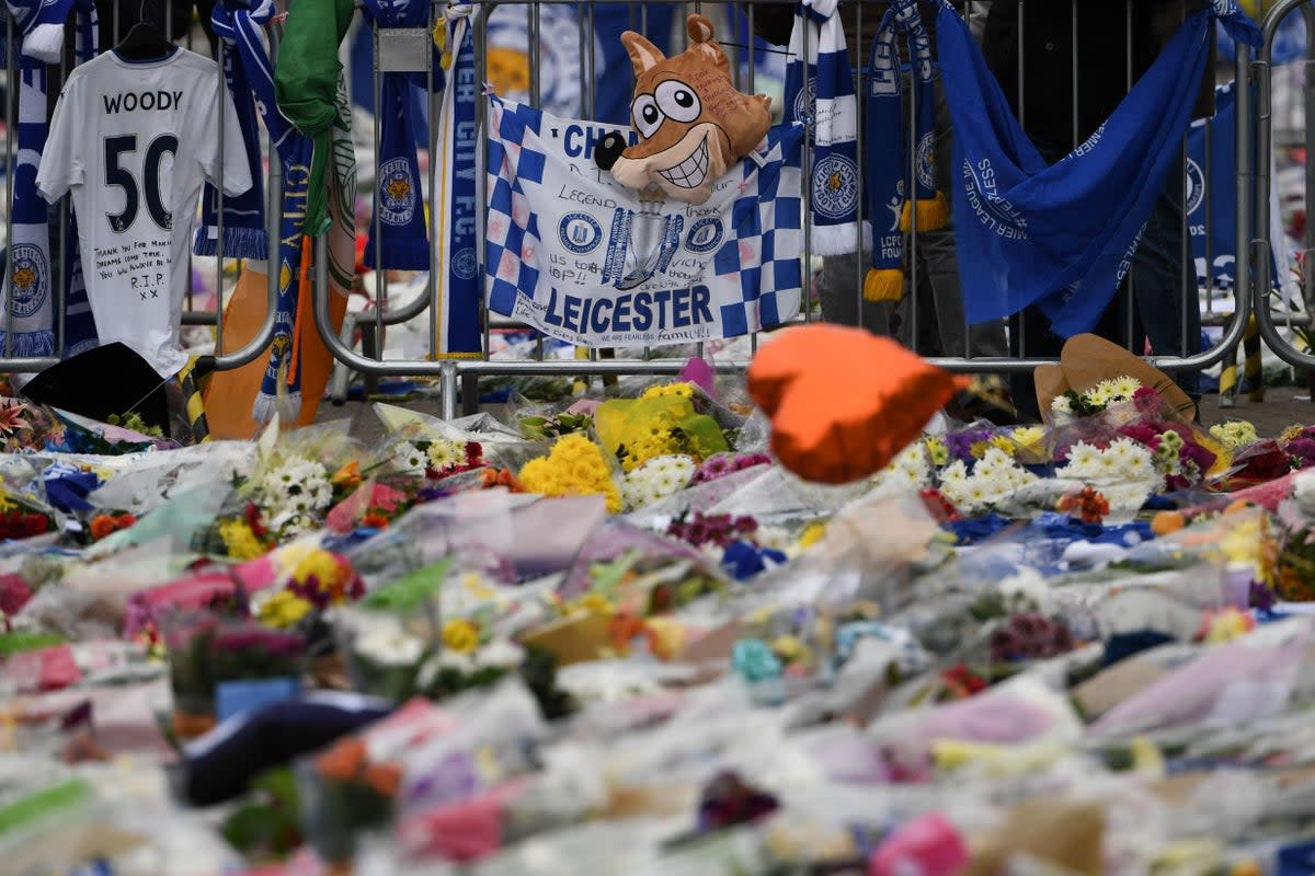 Flowers, balloons, scarfs and banners, including a fox balloon, are left in tribute outside Leicester City Football Club after the 2018 crash  (AFP/Getty Images)