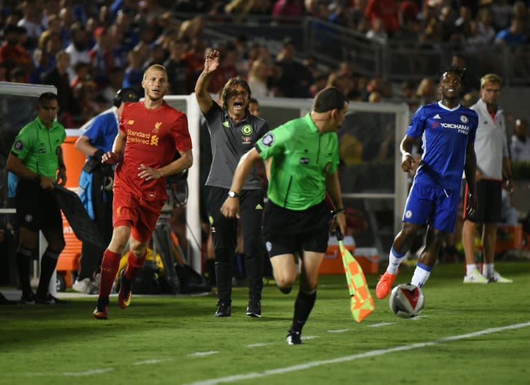 Chelsea coach Antonio Conte (C) gestures beside Liverpool player Ragnar Klavan (L) during the International Champions Cup match