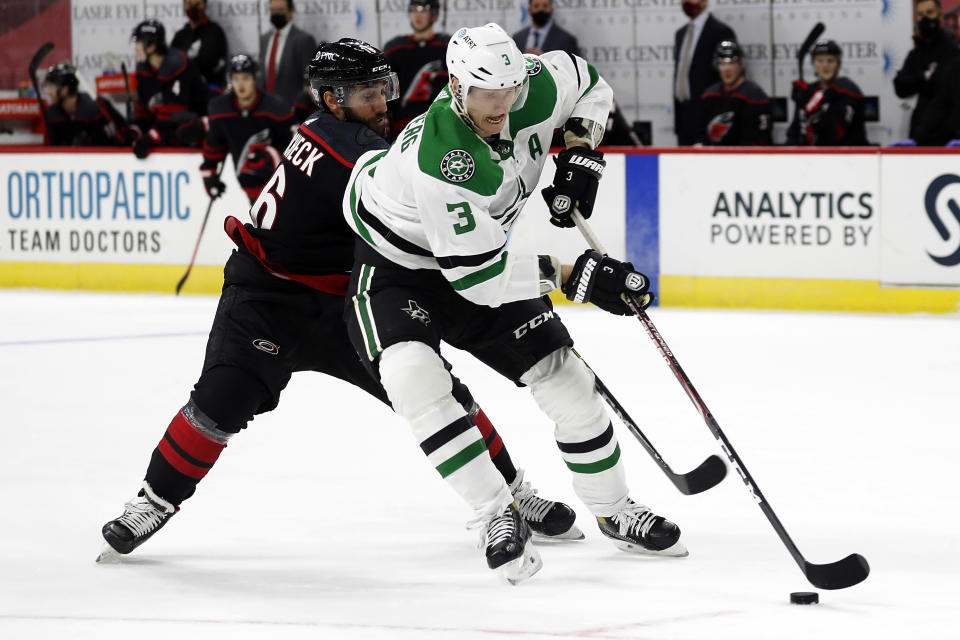 Dallas Stars' John Klingberg (3) tries to guard the puck from Carolina Hurricanes' Vincent Trocheck (16) during the second period of an NHL hockey game in Raleigh, N.C., Saturday, Jan. 30, 2021. (AP Photo/Karl B DeBlaker)