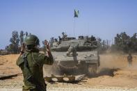 Israeli soldiers directs a tank at a staging ground near the border with the Gaza Strip, in southern Israel, Sunday, May 5, 2024. (AP Photo/Tsafrir Abayov)