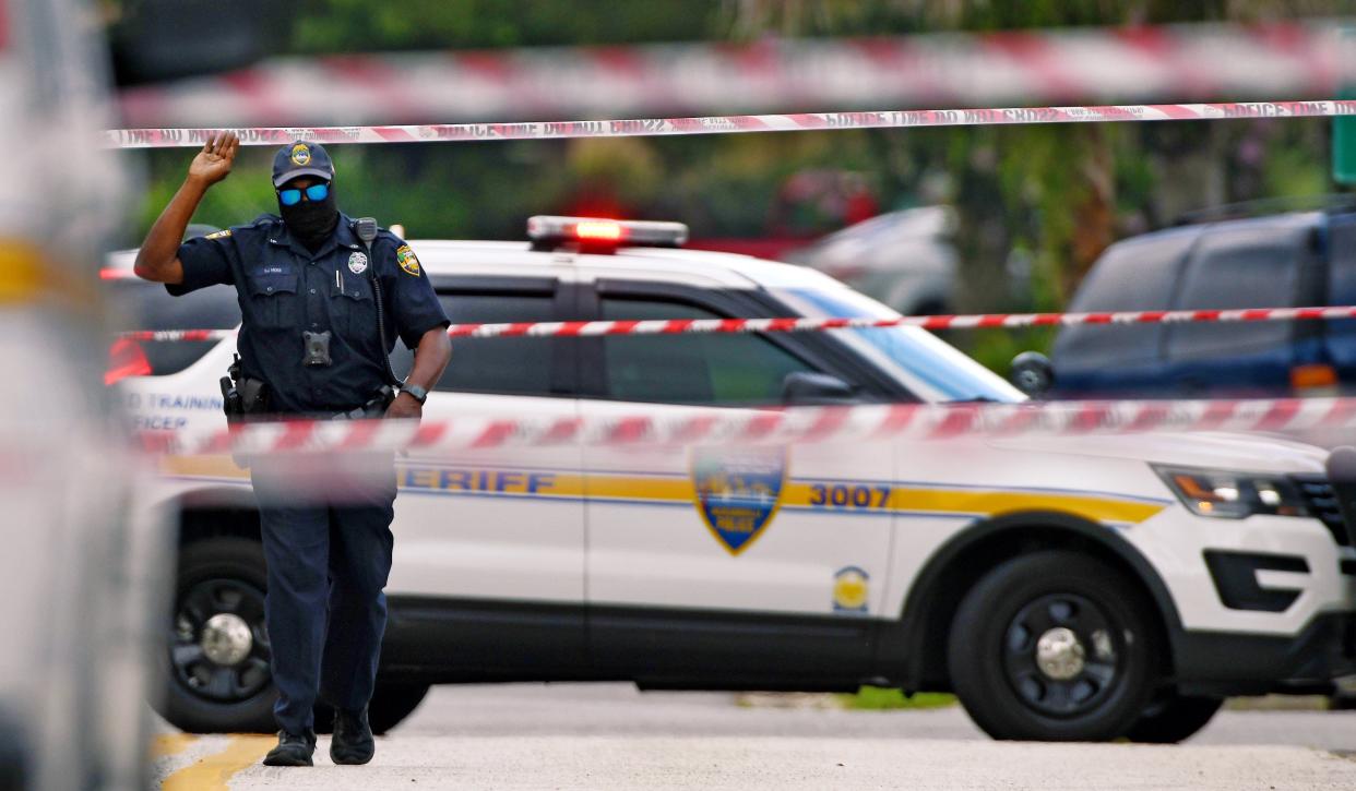 A Jacksonville sheriff's officer makes his way through crime-scene tape during an investigation.