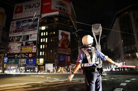 A police officer is seen during blackout after a powerful earthquake hit the area at a cross-point in Sapporo, Japan in this photo taken by Kyodo September 6, 2018. Mandatory credit Kyodo/via REUTERS