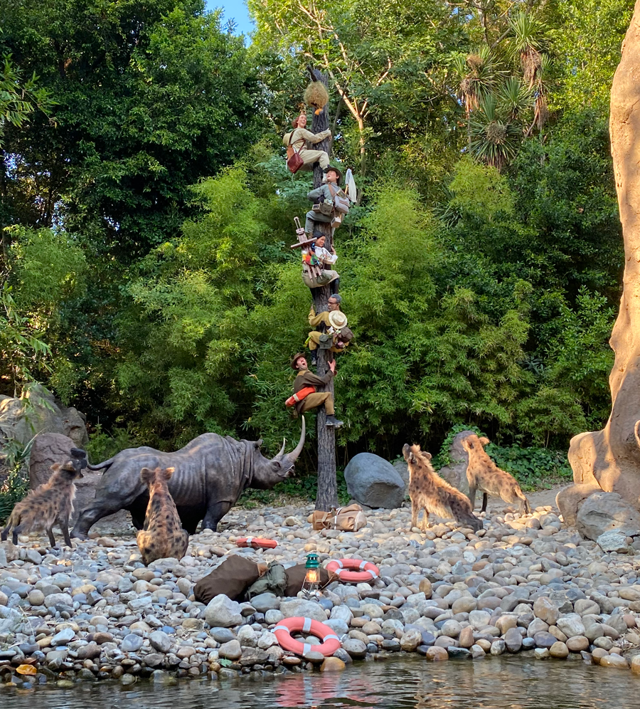 That group of people climbing up a tree pole, trying to escape animals attacking them