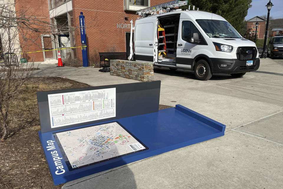 A toppled campus map and a repair vehicle appear on the University of Connecticut campus, in Storrs, Conn., Tuesday, April 4, 2023. Thousands of UConn fans, most of them students, spilled onto campus after watching a broadcast of the Huskies' NCAA Tournament win over San Diego State, Monday, April 3, 2023, with some pulling down signs and light poles, smashing windows and causing other damage. (AP Photo/Pat Eaton-Robb)