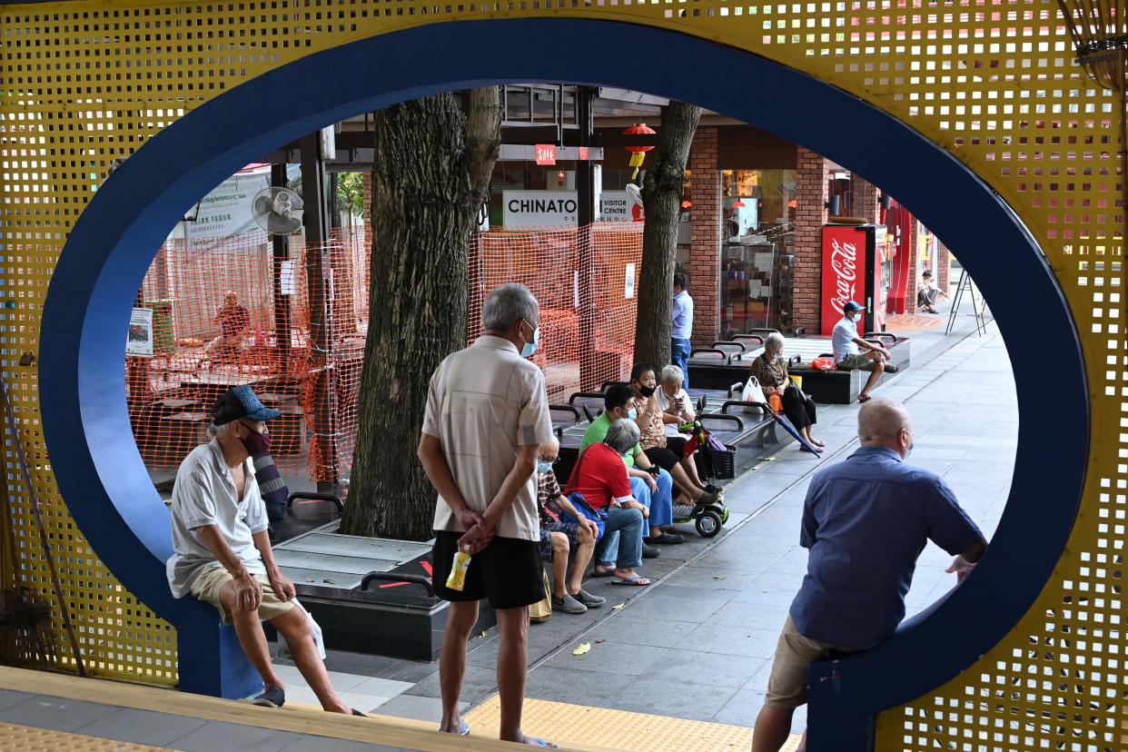 Elderly men look on in Singapore on June 19, 2020, as restrictions to prevent the spread of the COVID-19 novel coronavirus are eased. - Restaurants, retail shops and most other businesses reopened in Singapore on June 19 as the virus-hit city-state eased curbs, but the city-state's leader cautioned residents 