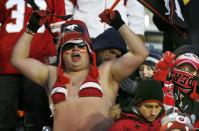 A male Calgary Stampeders fan wears a bikini to more suitably dressed fans during the second half of the CFL western final football game against the Saskatchewan Roughriders in Calgary, November 17, 2013. REUTERS/Todd Korol (CANADA - Tags: SPORT FOOTBALL)