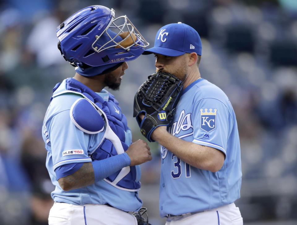 Kansas City Royals catcher Martin Maldonado and pitcher Ian Kennedy meet on the mound during the ninth inning of the team's baseball game against the Chicago White Sox on Saturday, March 30, 2019, in Kansas City, Mo. The Royals won 8-6. (AP Photo/Charlie Riedel)