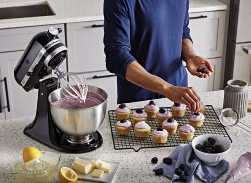 person making cupcakes with black stand mixer