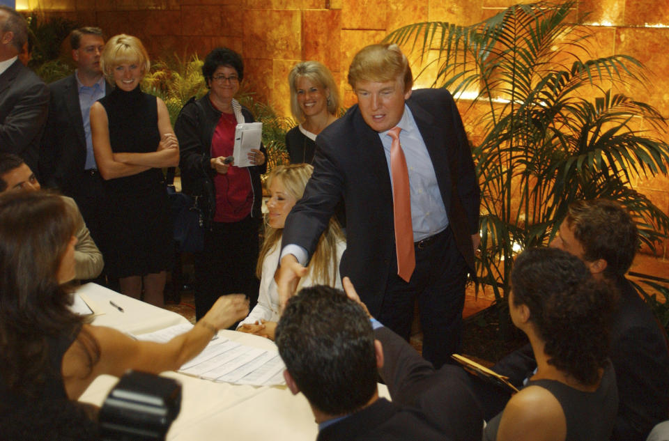 ARCHIVO - Donald Trump saluda a posibles candidatos del reality "The Apprentice" en el primer día de audiciones para la próxima temporada del programa el 30 de julio de 2004, en Nueva York. Versiones sobre el comportamiento de Trump en "The Apprentice" han hecho resurgir acusaciones de su supuesto maltrato a los concursantes negros del programa. (Foto AP/Jennifer Szymaszek, archivo)