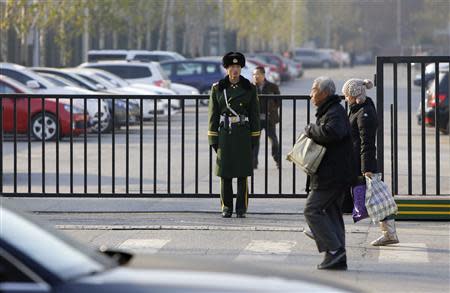 A paramilitary police official stands guard next to a fence, which blocks a road towards the South Korea embassy, in Beijing December 6, 2013. REUTERS/Jason Lee