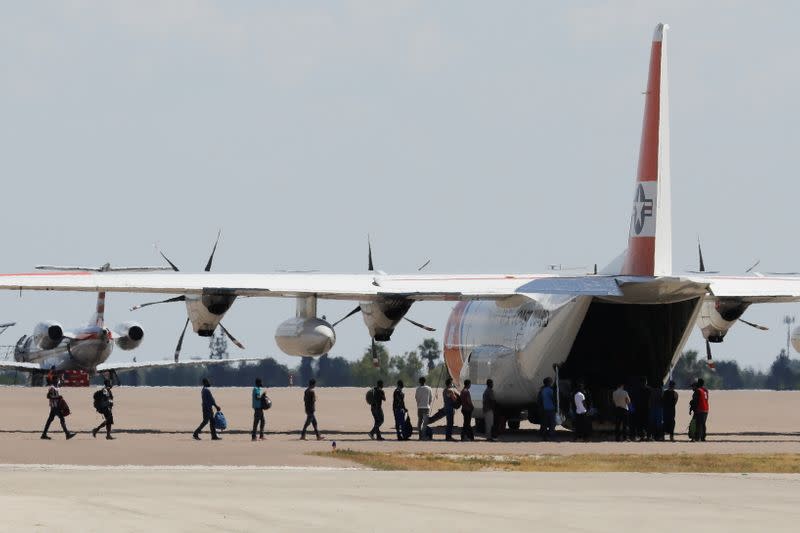 Migrants board a U.S. Coast Guard airplane at the Del Rio International Airport as U.S. authorities accelerate removal of migrants at border with Mexico, in Del Rio