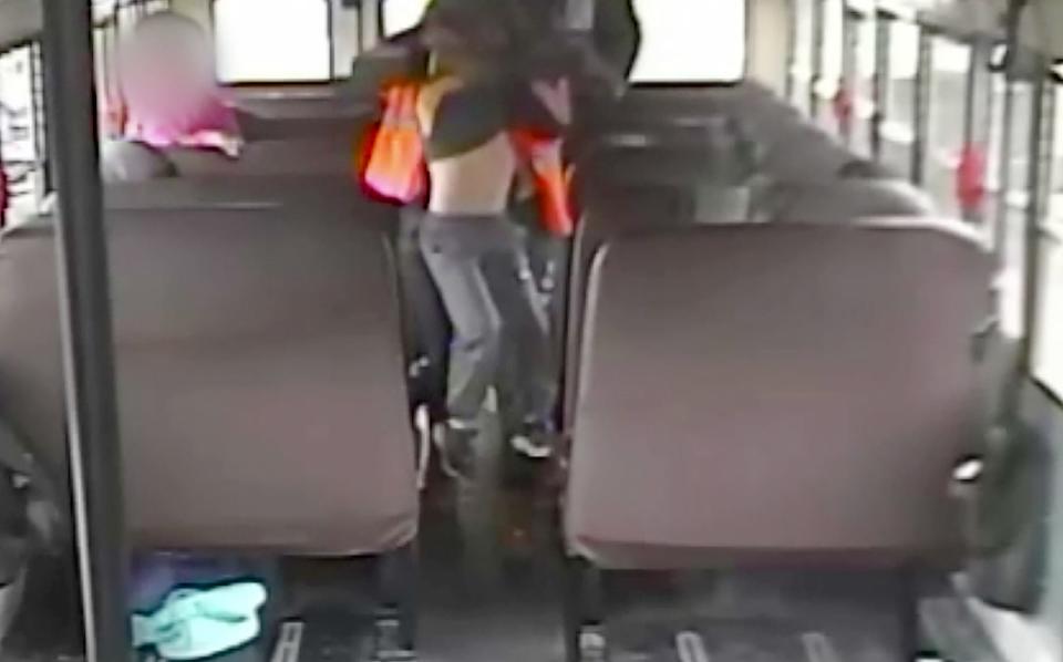 This video frame capture from the school bus where a 7-year-old autistic boy was assaulted by a school bus aide. In this image, the aide is carrying him to a seat in order to restrain him by using a special harness which is illegal for his diagnosis.