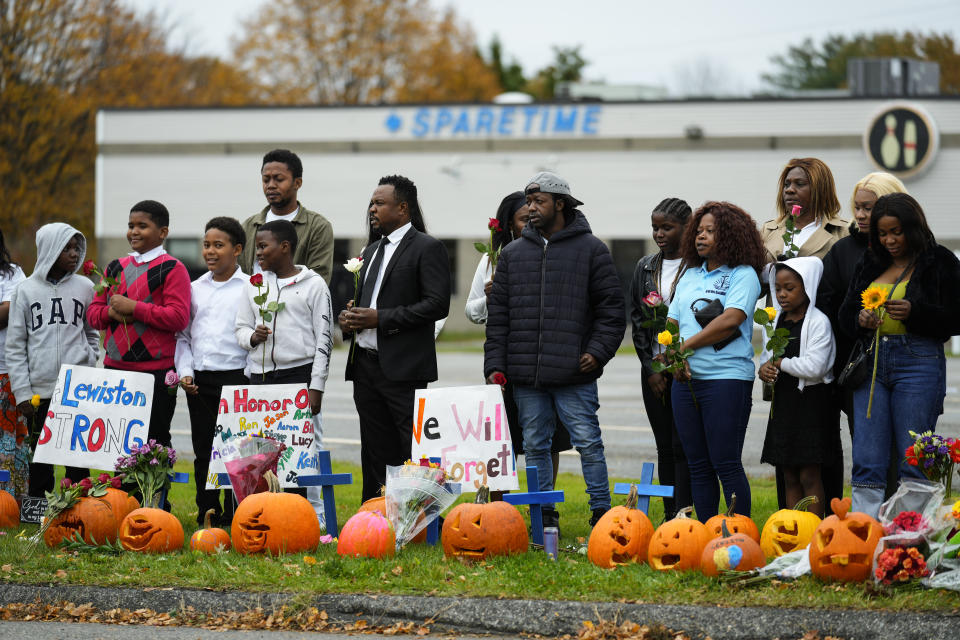 Members of the New Apostolic Church sing and pray at a makeshift memorial outside a bowling alley, the site of one of this week's mass shootings, Sunday, Oct. 29, 2023, in Lewiston, Maine. A gunman killed multiple people at the bowling alley and a bar in Lewiston on Wednesday. (AP Photo/Matt Rourke)