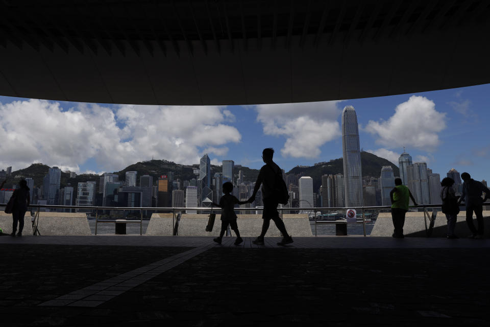 People walk at the waterfront of the Victoria Harbor of Hong Kong, Saturday, June 20, 2020. China's top legislative body has taken up a draft national security law for Hong Kong that has been strongly criticized as undermining the semi-autonomous territory's legal and political institutions. (AP Photo/Kin Cheung)