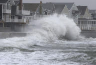 <p>Waves crash against a seawall and houses in Scituate, Mass., on March 7, 2018. (Photo: Steven Senne/AP) </p>