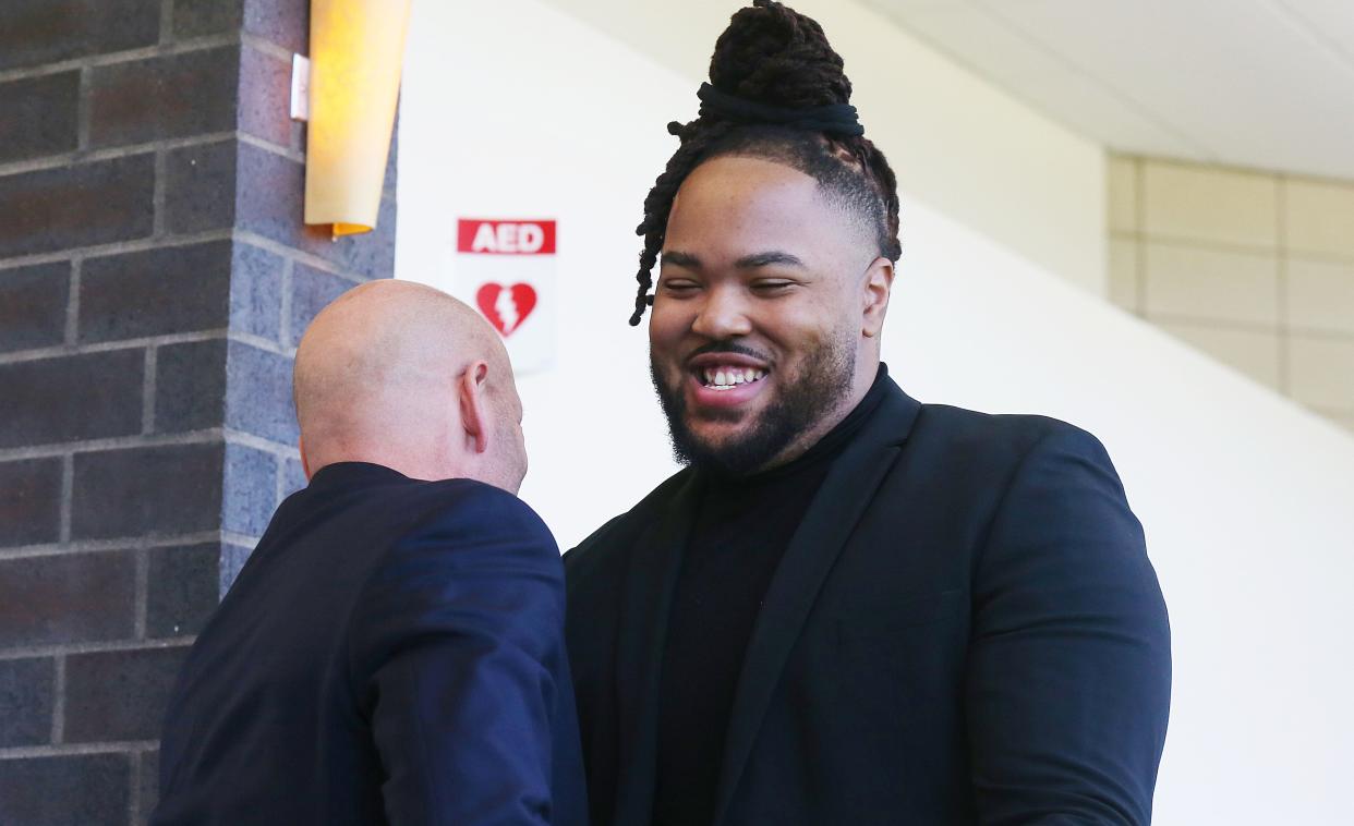 Former Iowa State foortball player Eyioma Uwazurike greets his attorney Van Plumb before a motion to dismiss hearing at Story County Courthouse on Oct. 20, 2023.