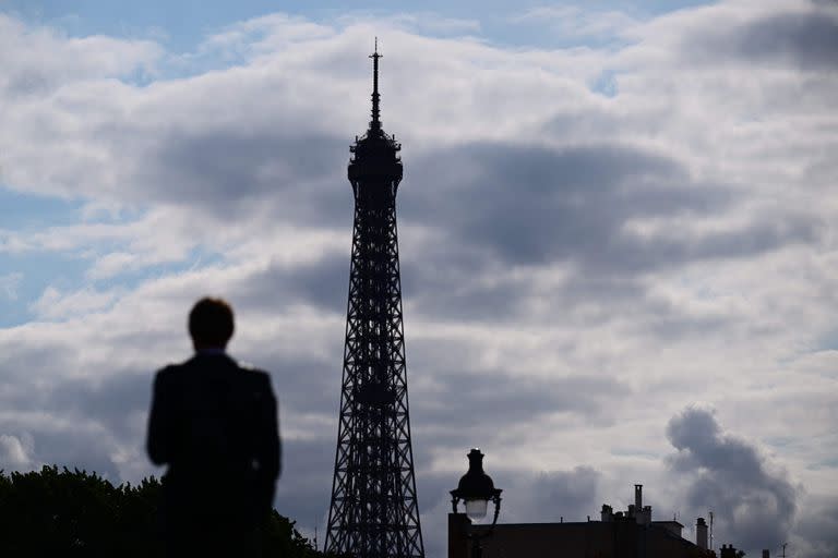 Un peatón camina frente a la Torre Eiffel, en París, el 19 de julio de 2023.