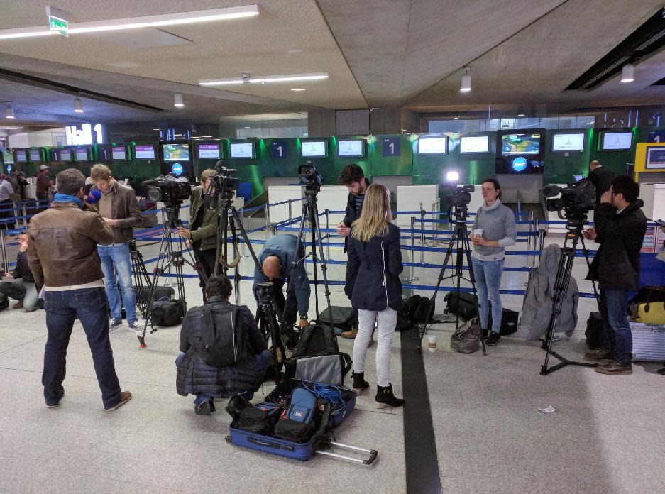 Reporters gather in front of the EgyptAir counter at Charles de Gaulle Airport outside of Paris. (AP Photo/Raphael Satter)