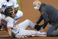 Baltimore Orioles' Anthony Santander (25) is assisted by a trainer after he was injured during the first inning of a baseball game against the Miami Marlins, Tuesday, April 20, 2021, in Miami. (AP Photo/Marta Lavandier)
