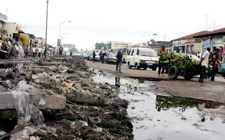 Traffic moves past pools of sewage and piles of rubbish along a street in the Democratic Republic of Congo's capital Kinshasa, in this May 5, 2005 file photo. REUTERS/David Lewis/Files