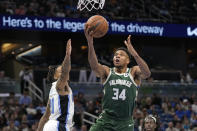 Milwaukee Bucks' Giannis Antetokounmpo (34) goes past Orlando Magic's Markelle Fultz, left, during the second half of an NBA basketball game, Monday, Dec. 5, 2022, in Orlando, Fla. (AP Photo/John Raoux)