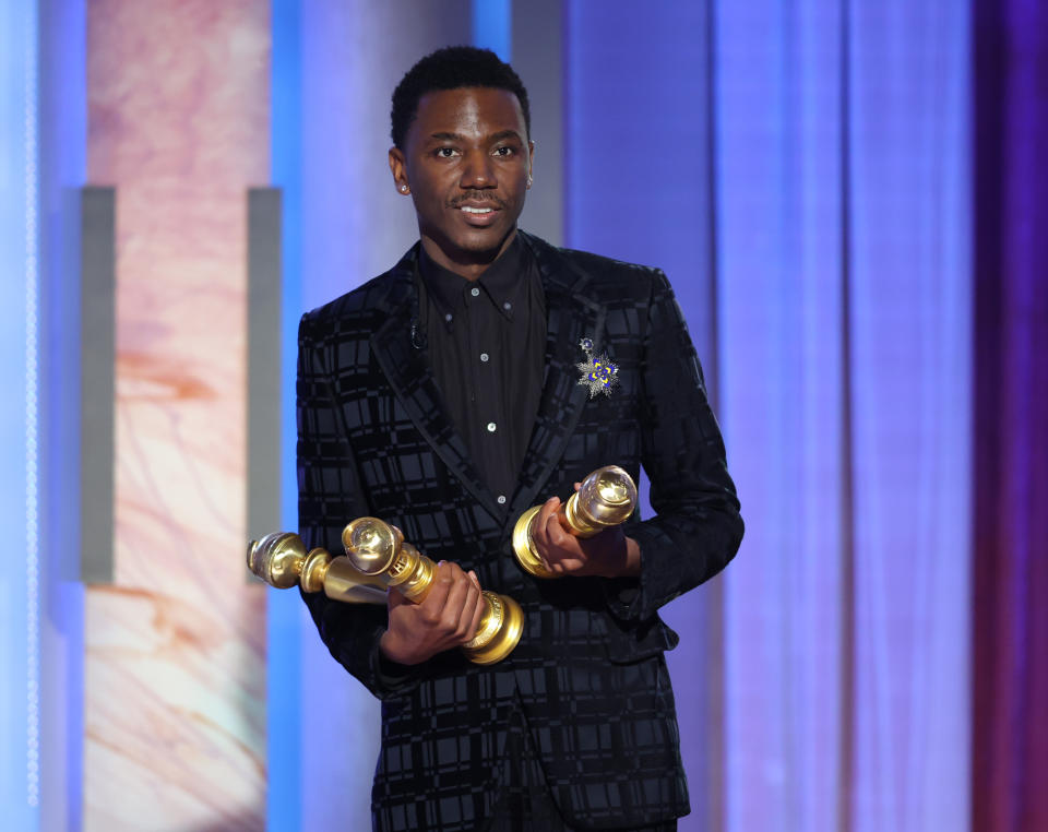 Jerrod Carmichael holding several Golden Globes