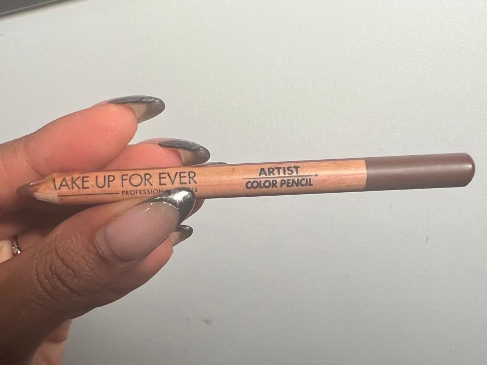 The writer holds a Makeup Forever lip liner