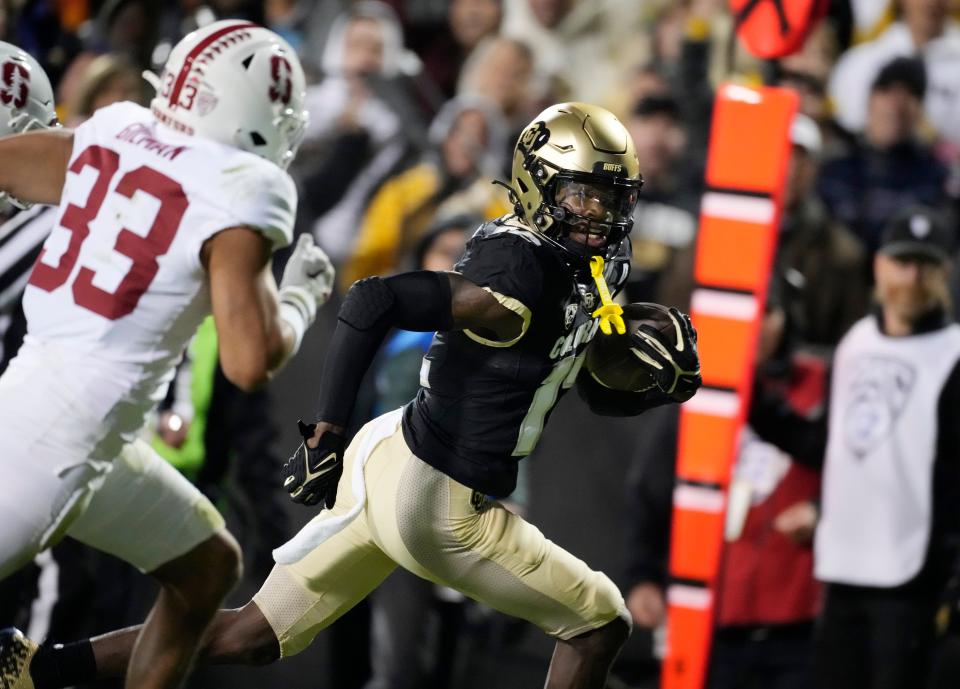 Colorado wide receiver Travis Hunter, right, runs past Stanford safety Alaka'i Gilman on the way to scoring a touchdown during the first half of an NCAA college football game Friday, Oct. 13, 2023, in Boulder, Colo.