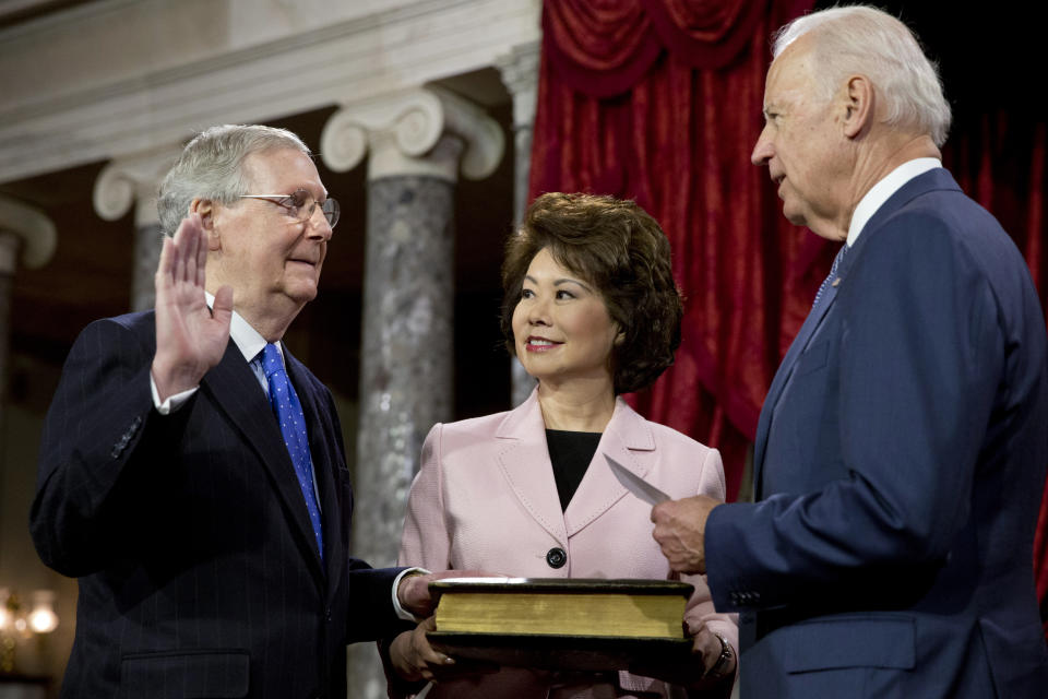 FILE - Vice President Joe Biden, right, administers the Senate oath to incoming Senate Majority Leader Mitch McConnell of Ky., with McConnell's wife, former Labor Secretary Elaine Chao, center, during a ceremonial re-enactment swearing-in ceremony, Jan. 6, 2015, in the Old Senate Chamber of Capitol Hill in Washington. By temperament and manner, Joe Biden and Mitch McConnell are decidedly mismatched. But as the days of divided government under Biden begin, their long relationship will become even more vital. McConnell’s experience in cutting deals and the political capital he retains among his members could leave him much freer to negotiate thorny matters with the White House. (AP Photo/Jacquelyn Martin File)