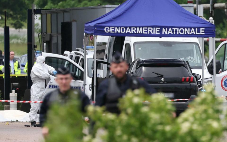 Police forensic teams work at the site of the ramming attack at the Incarville motorway toll in the Eure region of northern France