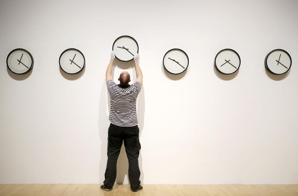 Gallery technician Tommy Stuart changes a series of nine clocks that tell the time on all the planets in our solar system, including the Earth's Moon which is part of the 'Between Poles and Tides' exhibition at the University of Edinburgh's Talbot Rice Gallery, which runs until 6 May.