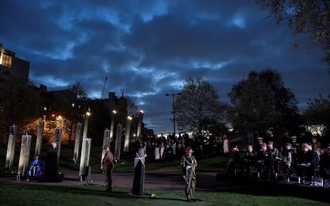 Dawn breaks over the London skyline during the service - Credit: TOBY MELVILLE /Reuters