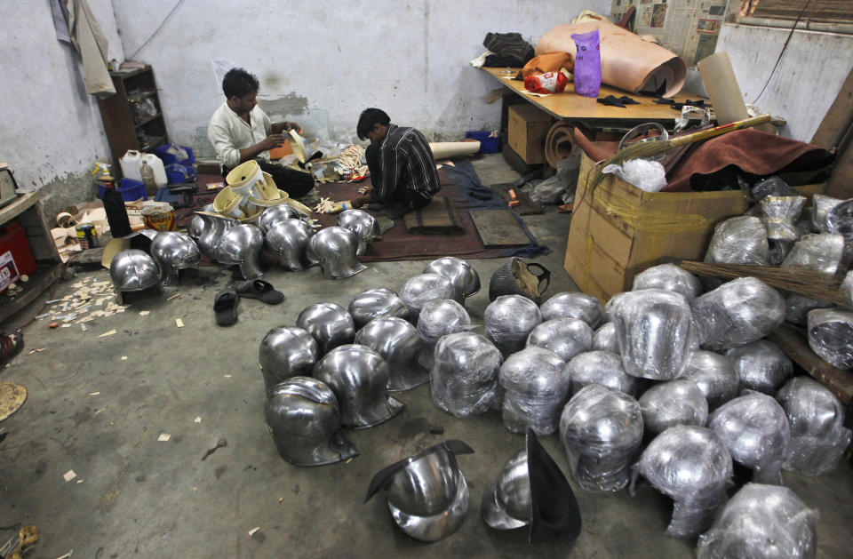 In this, June 2, 2012 photograph, workers prepare helmets for a Hollywood period movie at a workshop owned by Indian businessman Ashok Rai, unseen, in Sahibabad, India. From Hollywood war movies to Japanese Samurai films to battle re-enactments across Europe, Rai is one of the world's go-to men for historic weapons and battle attire. (AP Photo/Saurabh Das)