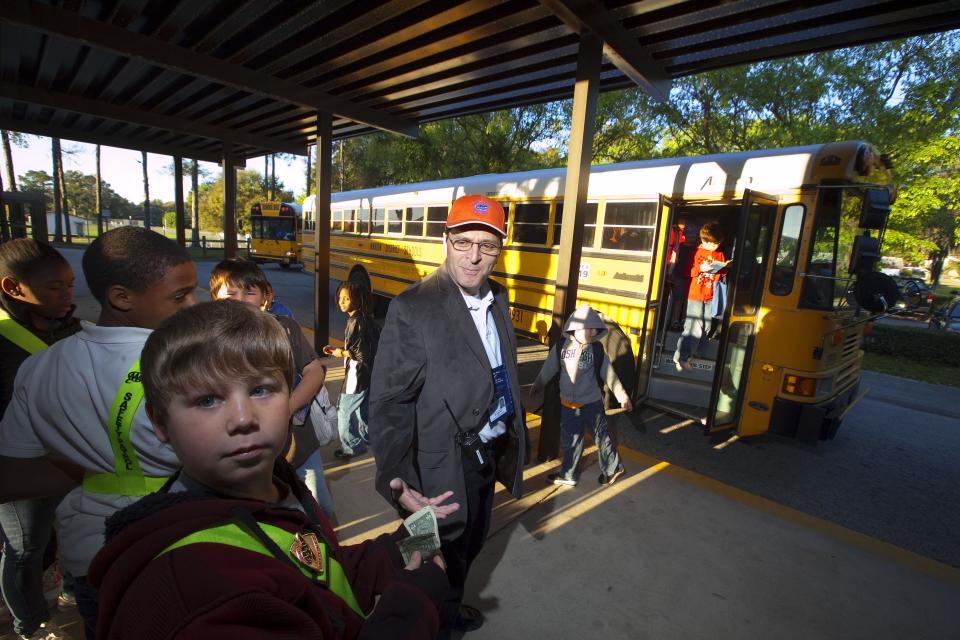 Joseph Suranni, then a Shady Hill Elementary School dean, guides students to their class as they depart the busses to begin school at Shady Hill Elementary in 2011.