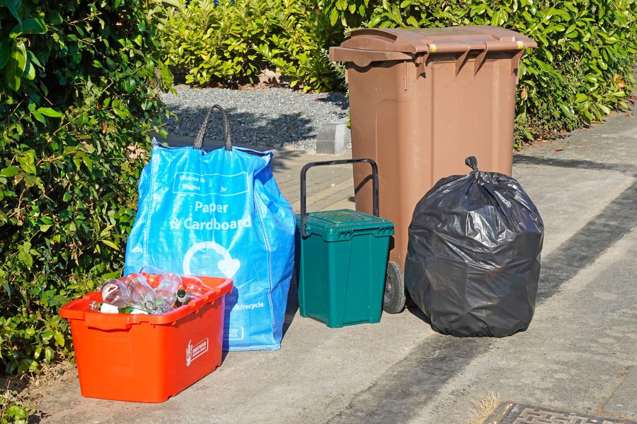 Rubbish collection uk waste sorted & segregated into recycling paper blue sack glass red bin green food caddy brown wheelie bin garden black landfill