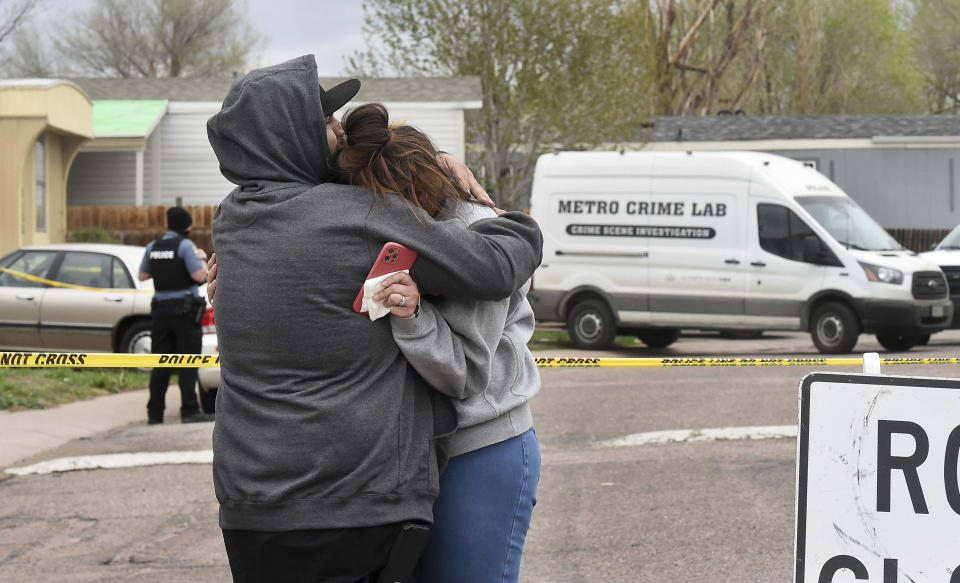 Freddy Marquez kisses the head of his wife, Nubia Marquez, near the scene where her mother and other family members were killed in a mass shooting early Sunday, May 9, 2021, in Colorado Springs, Colo. The suspected shooter was the boyfriend of a female victim at the party attended by friends, family and children. He walked inside and opened fire before shooting himself, police said. Children at the attack weren’t hurt and were placed with relatives. (Jerilee Bennett/The Gazette via AP)