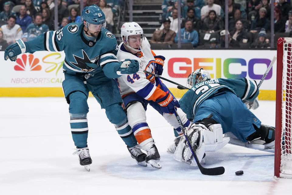 New York Islanders center Jean-Gabriel Pageau (44) scores against San Jose Sharks goaltender Kaapo Kahkonen, right, while defended by defenseman Erik Karlsson, left, during the first period of an NHL hockey game in San Jose, Calif., Saturday, March 18, 2023. (AP Photo/Godofredo A. Vásquez)