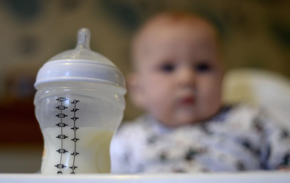 File photo dated 20/11/23 of a baby in a high chair looking towards her bottle of milk in the foreground. A new probe into the supply of baby formula milk has been launched by Britain's competition watchdog after it found that average prices had soared by 25% in the past two years. The Competition and Markets Authority (CMA) said it has begun a market study into formula supply following findings last November of an initial review into the sector. Issue date: Tuesday February 20, 2024.