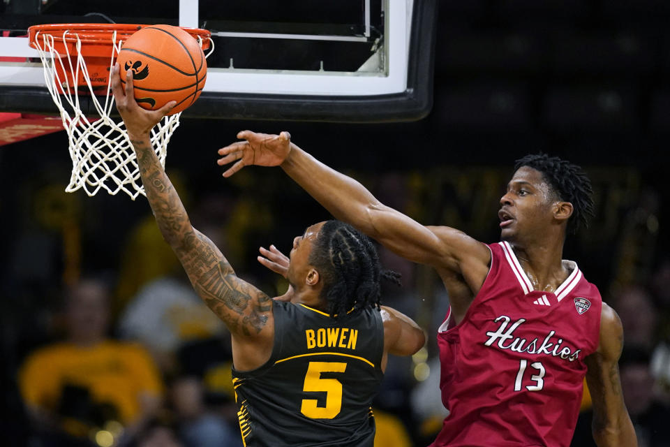 Iowa guard Dasonte Bowen (5) drives to the basket past Northern Illinois forward Xavier Amos (13) during the first half of an NCAA college basketball game, Friday, Dec. 29, 2023, in Iowa City, Iowa. (AP Photo/Charlie Neibergall)