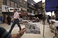 Varios compradores recorren el 16 de marzo de 2013 el distrito de comercial de Karrada, en Bagdad, el mismo que retrató Hadi Mizban el 29 de septiembre de 2008 tras la explosión de una bomba que dejó 22 muertos. AP Photo/Maya Alleruzzo