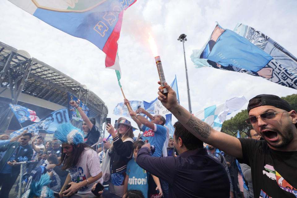 Napoli fans celebrate outside the Diego Maradona stadium in Naples, Italy, Sunday, April 30, 2023. After Napoli's game was moved to Sunday, the team could secure the title in front of their own fans by beating Salernitana — if Lazio fails to win at Inter Milan earlier in the day. Diego Maradona led Napoli to its only previous Serie A titles in 1987 and 1990. (AP Photo/Gregorio Borgia)