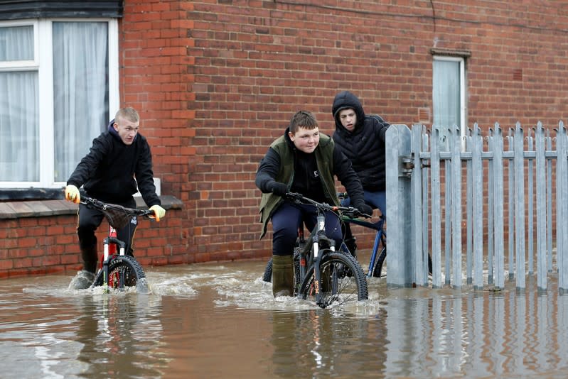 Residents cycle through floodwater in Bentley, north of Doncaster