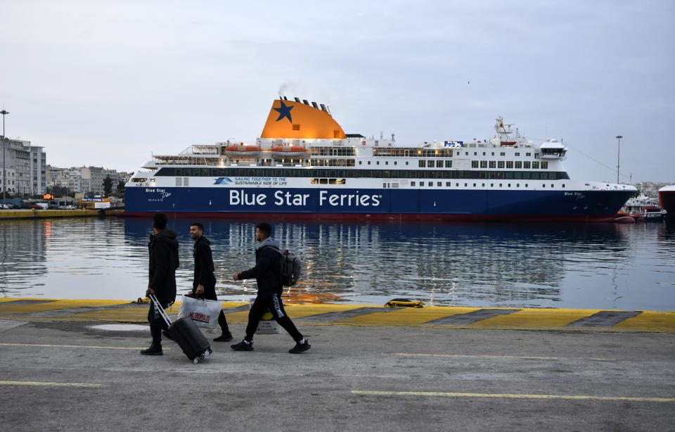 People with bags walk at the port of Piraeus, near Athens as the ferries are docked during a strike on Wednesday, Feb. 28, 2024. A nationwide 24-hour strike by public and some private sector workers is expected to disrupt public transport and leave ferries tied up in port. (AP Photo/Michael Varaklas)