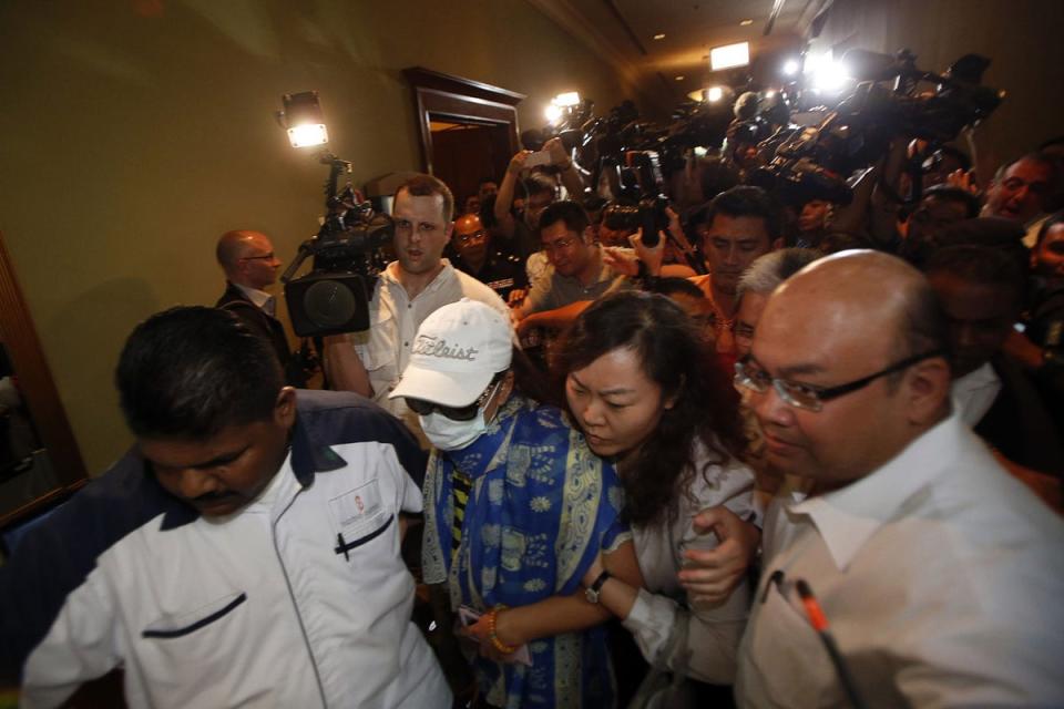 Chinese family members of missing Malaysia Airlines MH370 passengers are escorted away from a media conference in Kuala Lumpur (Reuters)