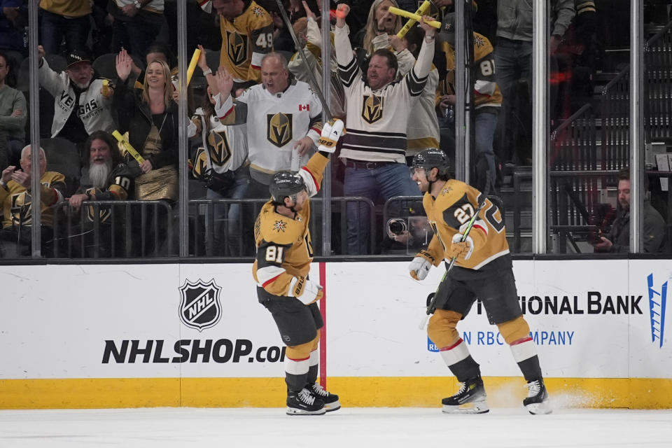 Vegas Golden Knights defenseman Shea Theodore (27) celebrates after Vegas Golden Knights right wing Jonathan Marchessault (81) scored against the Vancouver Canucks during the first period of an NHL hockey game Tuesday, April 2, 2024, in Las Vegas. (AP Photo/John Locher)