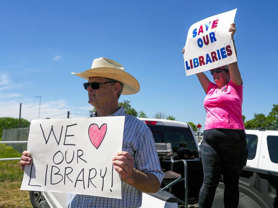 Residents of Llano County, Texas hold a protests in support of local libraries on April 13, as county leaders held a special meeting to consider shutting their public library system rather than follow a federal judge's order to return books to the shelves on themes ranging from teen sexuality to bigotry.  (Aaron E. Martinez/Austin American-Statesman/The Associated Press - image credit)